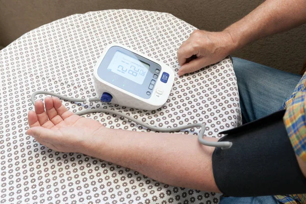 Blood pressure measuring and heart rate checking using digital device — Stock Photo, Image