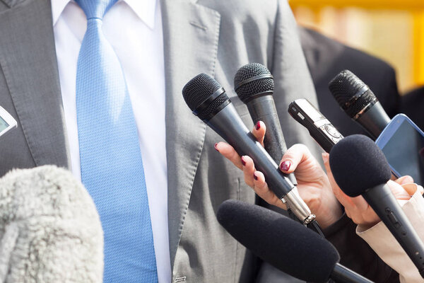 Politician or business person talking with media at press conference