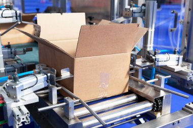 Depo veya dağıtım merkezindeki otomatik paketleme hattında karton paket kutusu