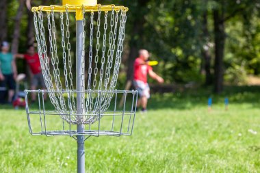 İnsanlar parkta uçan disk golf oynuyorlar.
