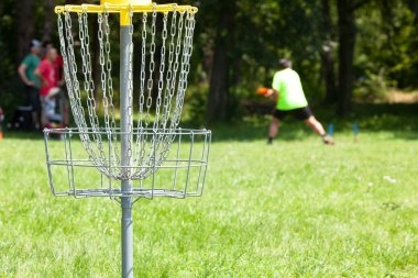 Şehir parkında uçan disk golf oyunu oynayan adam.