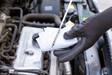 Arabadaki motor yağı seviyesini ölçüyorum.