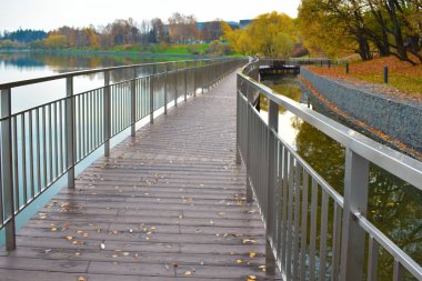 Şehir göletinde yaya yolu köprüsü. Parktaki metal dolgu..