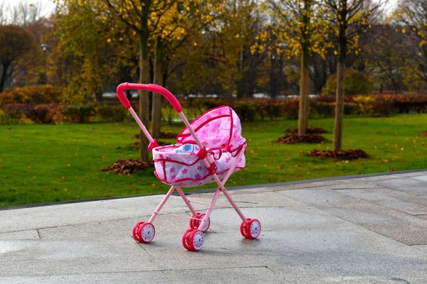 粉色婴儿车忘在城市公园里了。 小孩把婴儿车弄丢了. — 图库照片