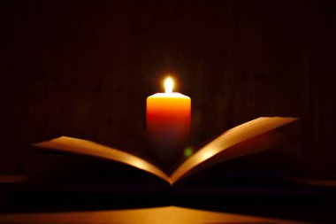 Esrarengiz kitap ve siyah mum. Sihirli edebi karanlık arkaplan.