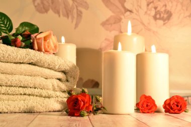 Spa salonu ve banyo konsepti. Havlu, güller ve mumlar. Spa otelinde rahatlama ve keyif..