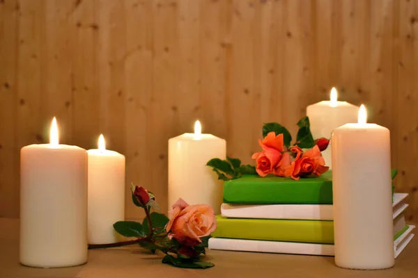 Romantischer Hintergrund mit Kerzen, Büchern und Blumen auf einem Holz. Bild für die Schönheits- und Gesundheitsbranche. — Stockfoto