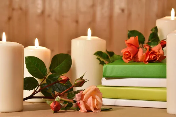 Romantyczne tło ze świecami, książkami i kwiatami na drewnie. Obraz dla przemysłu kosmetycznego i zdrowotnego. — Zdjęcie stockowe