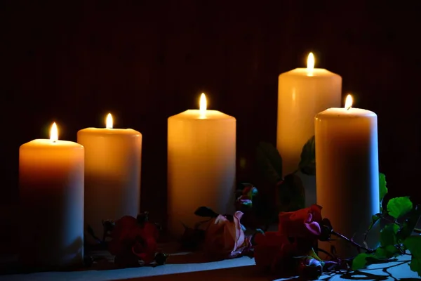 Begrafenisherdenking achtergrond. Vaarwel condoleances behang. Dag van herinnering en verdriet. Denk eraan en rouw. Diverse witte kaarsen met bloemen op zwart. — Stockfoto