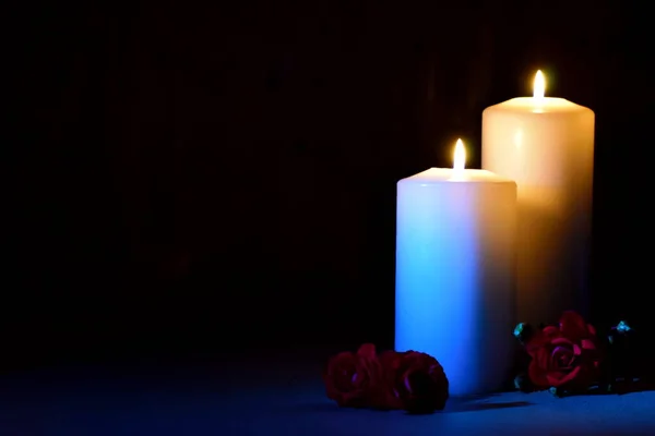 Day of memory and sorrow. Remember and mourn. Two white candles with flowers on black. — Stockfoto