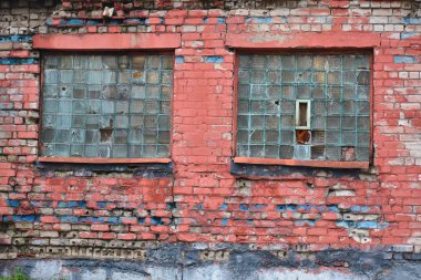 Eski kırmızı tuğla duvar. Kırık camlı eski püskü bir ev duvarı..