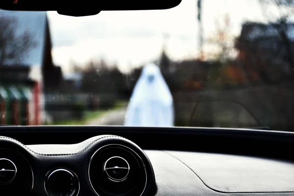 Hantu di jalan. Membawa di depan mobil. Sopir melihat hantu putih di depan kap mobil . — Stok Foto