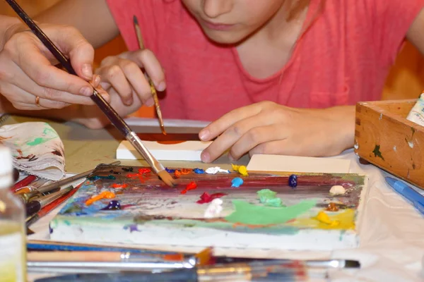 Уроки рисования. Мэзер учит дочь рисовать масляными красками . — стоковое фото