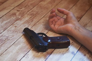 Silah ve kadın eli. Depresyondan dolayı intihar. Kadın intihar etti..