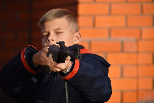 El chico dispara un arma. Adolescente con pistola. El niño está aprendiendo a disparar — Foto de Stock