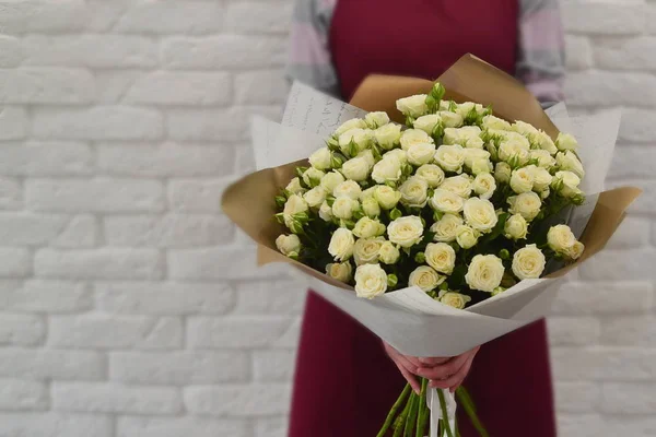 Ramo de flores en manos de mujer. Mujer con flores para una tienda de catálogo — Foto de Stock