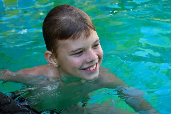 Rapaz sorridente na piscina. Treinamento de natação — Fotografia de Stock