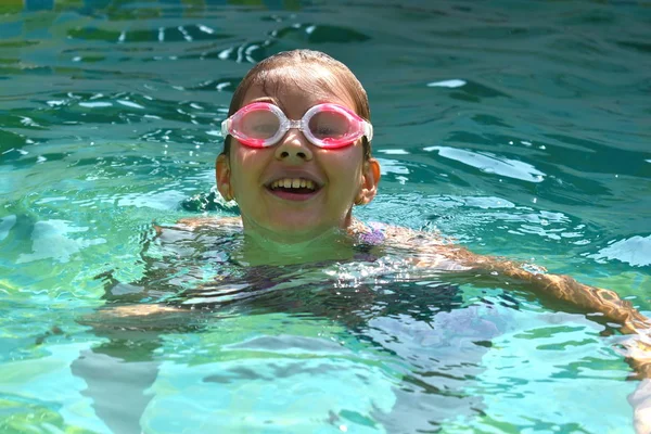 一个戴着泳镜的女孩的画像。 快乐的女孩在游泳池里游泳 — 图库照片