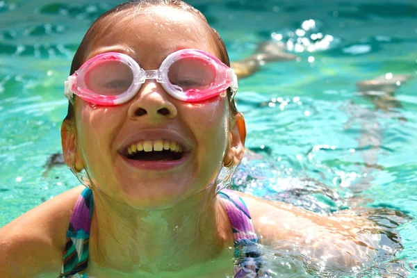 Retrato de uma menina em óculos de natação. Menina feliz nada na piscina — Fotografia de Stock