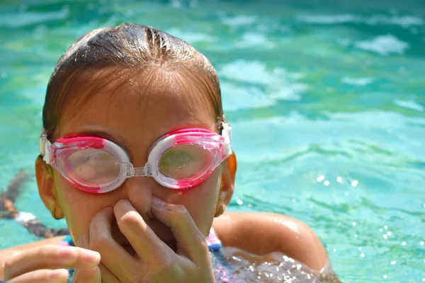 Retrato de uma menina em óculos de natação. Menina feliz nada na piscina — Fotografia de Stock