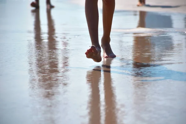 Ноги ходят по пляжному песку. Прогулки по берегу моря . — стоковое фото
