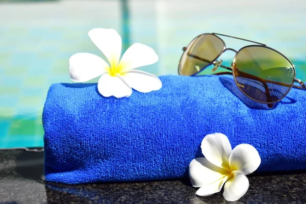 Óculos, toalhas e flores na água. Hora de verão e relaxe — Fotografia de Stock