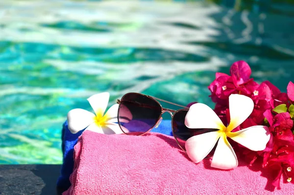 Umas férias relaxantes no mar. Toalhas, copos e flores na água. Conceito de spa de beleza para corpo . — Fotografia de Stock