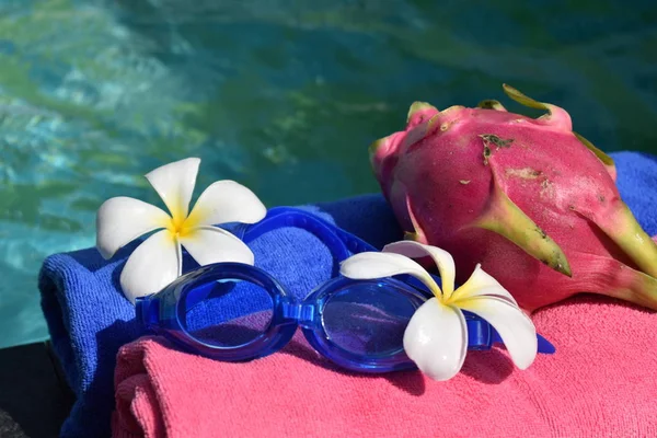 Umas férias relaxantes no mar. Toalhas, copos e flores na água. Conceito de spa de beleza para corpo . — Fotografia de Stock