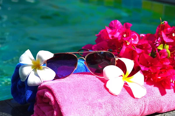 Umas férias relaxantes no mar. Toalhas, copos e flores na água. Conceito de spa de beleza para corpo . — Fotografia de Stock