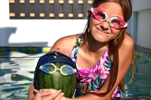 Chica con una sandía en la piscina. Sandía en vasos de agua . —  Fotos de Stock