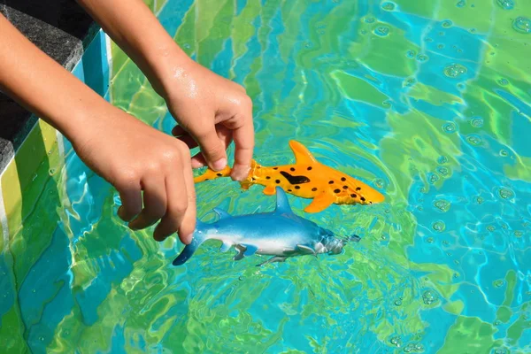 Kinder spielen mit Spielzeug im Pool. Spielzeug für das Schwimmbad. — Stockfoto