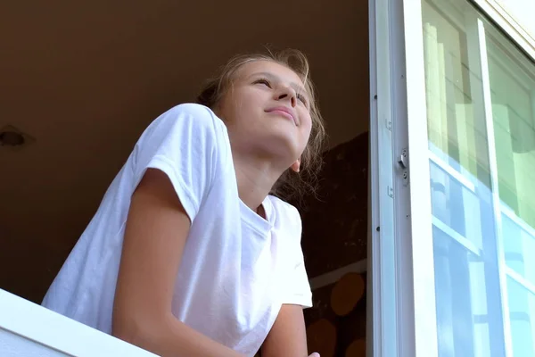 Gadis kecil bersandar di jendela. Anak menikmati pagi hari . — Stok Foto