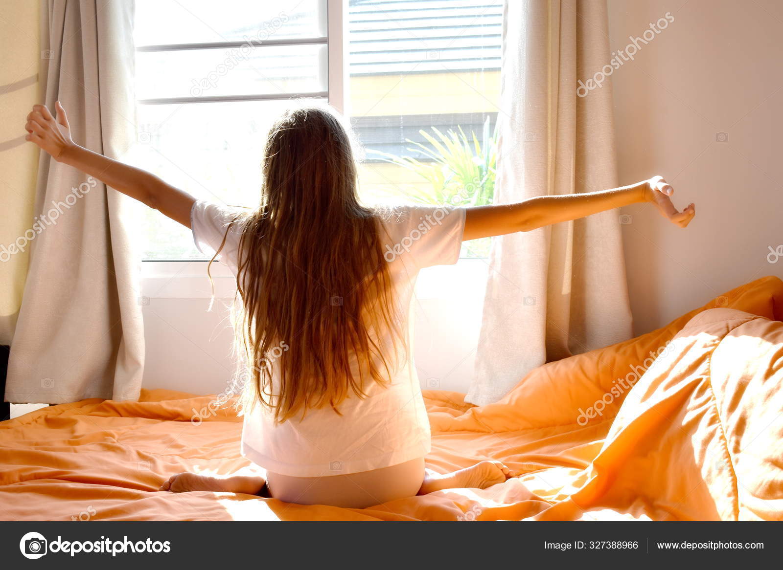 A girl wakes up at the window in the morning. Happy sunny morning