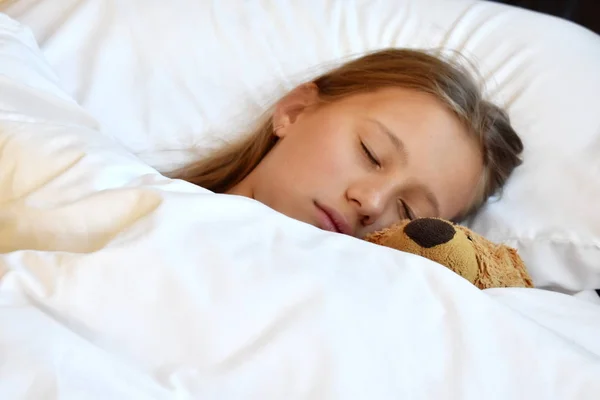Menina dormindo com um ursinho. A criança está dormindo docemente — Fotografia de Stock