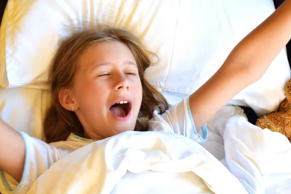 Criança a acordar na cama. Manhã feliz na cama . — Fotografia de Stock