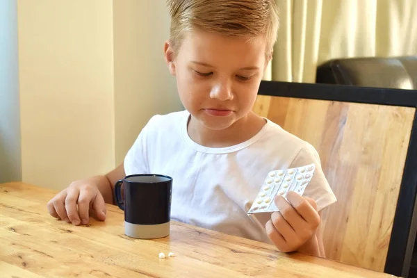 Een jongetje die pillen eet. De jongen drinkt medicijnen.. — Stockfoto