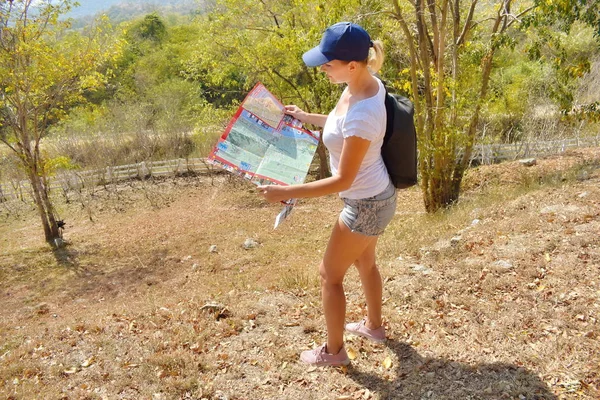 Eine Frau schaut auf eine Straßenkarte. ein Mädchen in den Bergen — Stockfoto