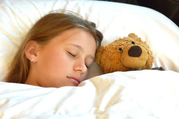 Menina dormindo com ursinho de pelúcia. A criança que dorme docemente . — Fotografia de Stock