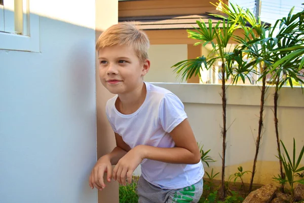 Versteckspiel. Junge schleicht an der Wand entlang. das Kind schleicht durch das Haus. — Stockfoto