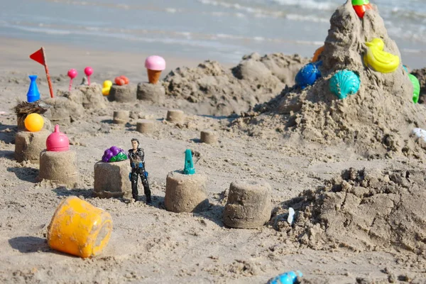 Sand castle toys. The children built a sand pyramid . Games on the beach. Summer school holidays. Beach baby figurines.