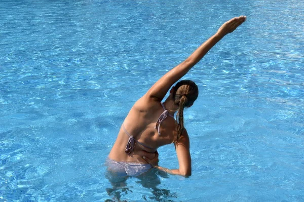 Ćwiczenia w basenie. Dziewczyna ćwiczy w basenie. aktywny sport. piękna kobieta w stroju kąpielowym w treningu wodnym — Zdjęcie stockowe