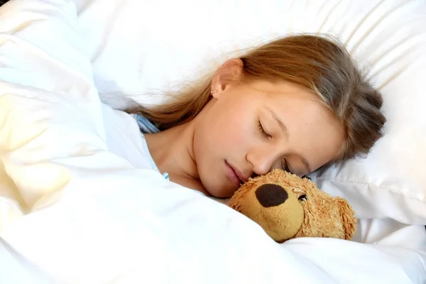Puberťačka spí s medvídkem. Oblíbená hračka v posteli. Sladký zdravý spánek dítěte. — Stock fotografie