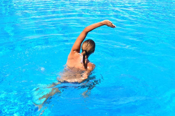 Ćwiczenia w basenie. Dziewczyna ćwiczy gimnastykę w wodzie. Aktywne sporty wodne. Aqua-fitness dla kobiet. — Zdjęcie stockowe
