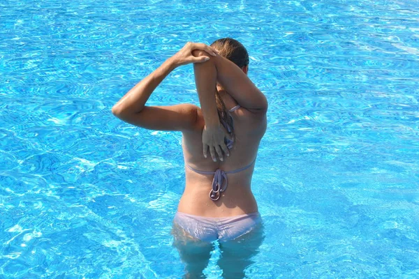 Exercício na piscina. Menina fazendo exercícios de ginástica na água. Esportes aquáticos ativos. O Aqua-fitness para mulheres . — Fotografia de Stock