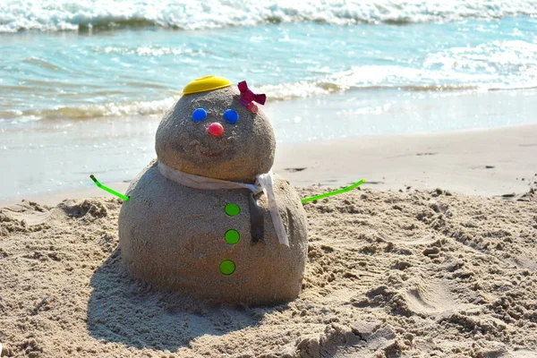 Песочный человек Новый год в тропиках. Рождество в море. Снеговик из песка на берегу. С Новым годом на острове. Мусорщик — стоковое фото