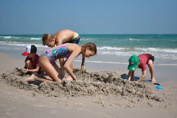 . Dzieci bawią się razem na piaszczystej plaży. Ośrodek dla dzieci nad morzem. — Zdjęcie stockowe