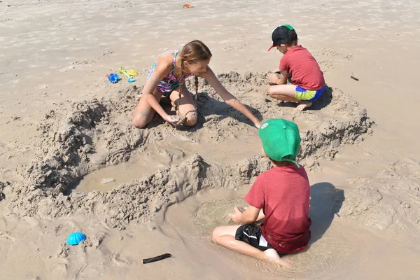 Дети играют вместе на песчаном пляже. Children 's resort on the sea. — стоковое фото