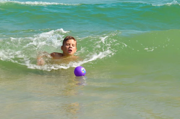 Niño jugando en el mar. Niño salpicando en la puerta del agua. Tus vacaciones en el mar. Juegos en el océano . — Foto de Stock