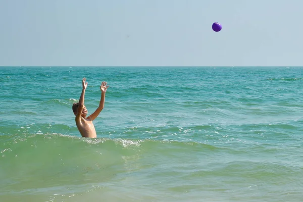 Een jongetje dat in zee speelt. Kind spetterend in het water autdoor. Uw vakantie op zee. Spelen in de oceaan. — Stockfoto