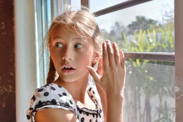 Cute child girl peeking. Beautiful girl peeping. The Sly glance of the child. The child spies. Hide-and-seek. — Stock Photo, Image